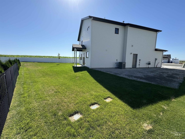 rear view of house featuring fence and a lawn