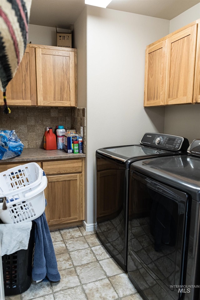 washroom with washer and clothes dryer and cabinets