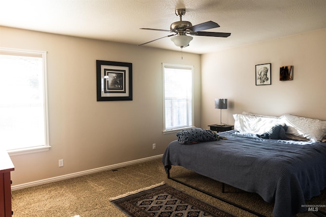 carpeted bedroom featuring ceiling fan and multiple windows