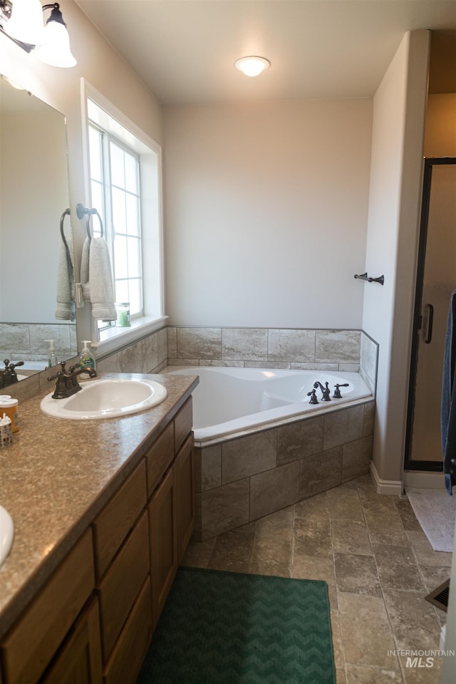 bathroom with a relaxing tiled tub and vanity