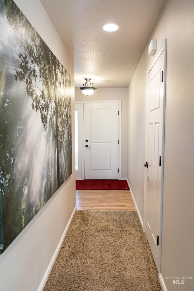 corridor with a textured ceiling and carpet