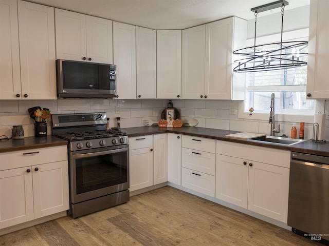 kitchen featuring stainless steel appliances, sink, and white cabinets