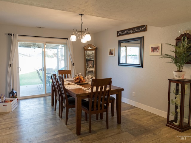 dining space with dark hardwood / wood-style floors, a chandelier, and plenty of natural light