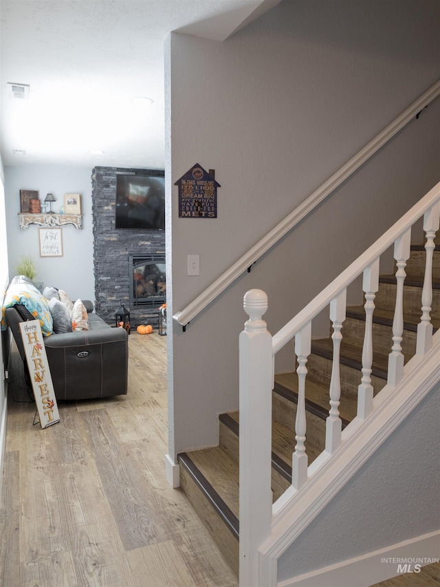 stairway featuring a fireplace and wood-type flooring