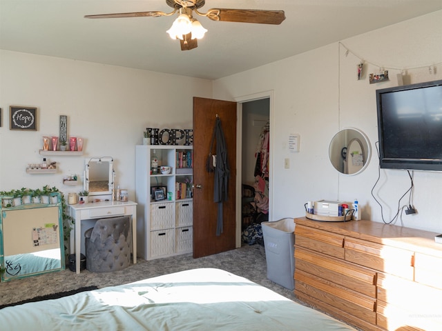 carpeted bedroom with a walk in closet, a closet, and ceiling fan