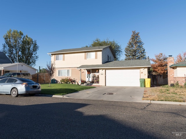 view of property featuring a garage and a front lawn