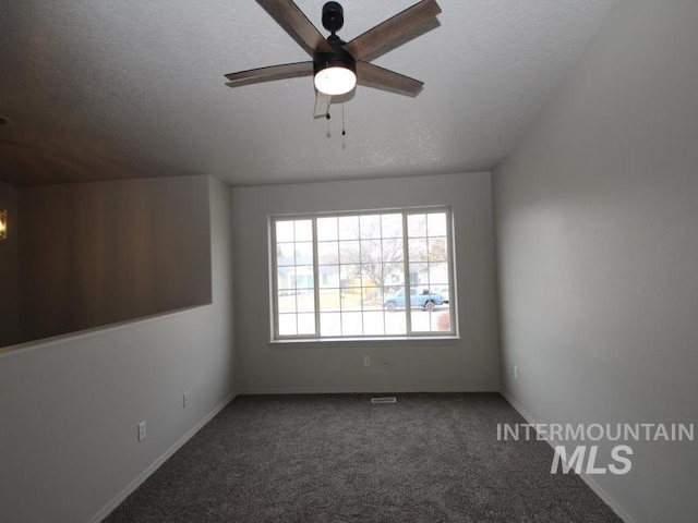 empty room featuring a textured ceiling, ceiling fan, carpet flooring, and baseboards