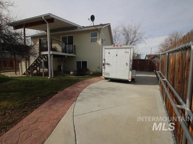 view of side of property with a storage shed, a fenced backyard, stairs, and an outdoor structure