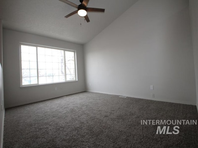 spare room featuring lofted ceiling, a textured ceiling, carpet flooring, and a ceiling fan