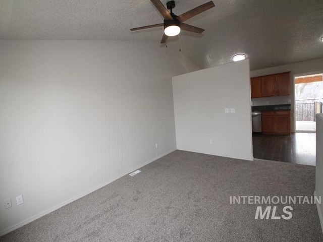 unfurnished room featuring ceiling fan, dark colored carpet, and a textured ceiling