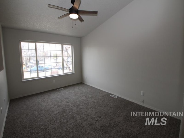 empty room featuring visible vents, a ceiling fan, carpet, vaulted ceiling, and a textured ceiling