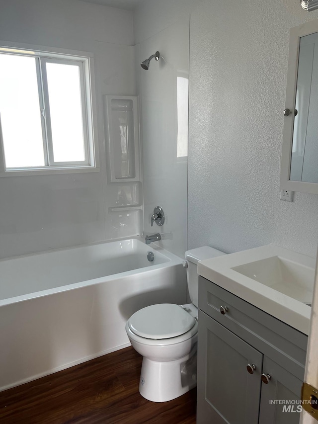 1224 Colorado, Gooding, ID 83330 - bathroom with vanity, toilet, wood finished floors, bathtub / shower combination, and a textured wall
