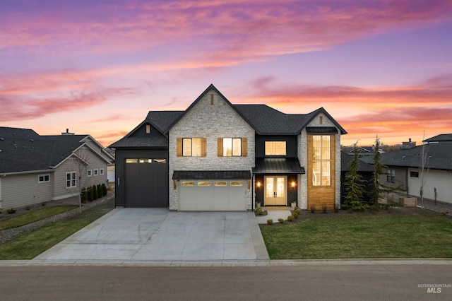 view of front of property with an attached garage, a lawn, stone siding, and driveway