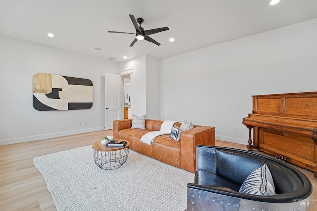 living area with light wood finished floors, recessed lighting, a ceiling fan, and baseboards