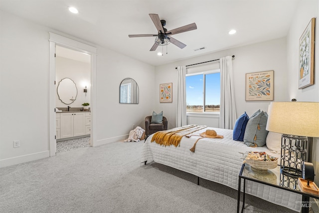 carpeted bedroom with visible vents, recessed lighting, ensuite bath, and baseboards