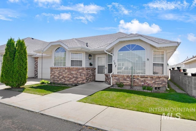 view of front of property with brick siding, a garage, fence, and a front yard