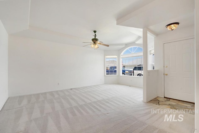 carpeted entrance foyer featuring a ceiling fan and baseboards
