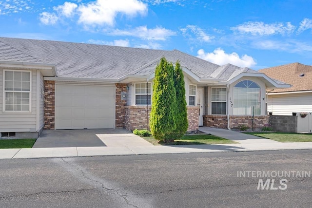 ranch-style home featuring an attached garage, driveway, and brick siding