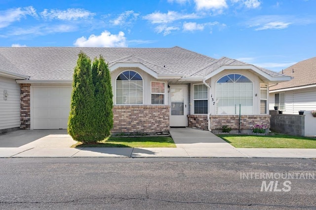 view of front of home featuring a garage, driveway, and a shingled roof