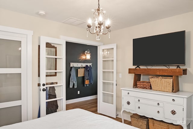 bedroom featuring french doors, dark hardwood / wood-style floors, and a notable chandelier