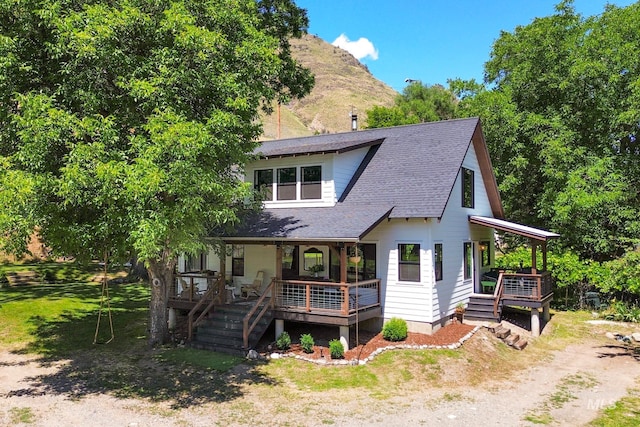 view of front of property with a mountain view, a front yard, and covered porch