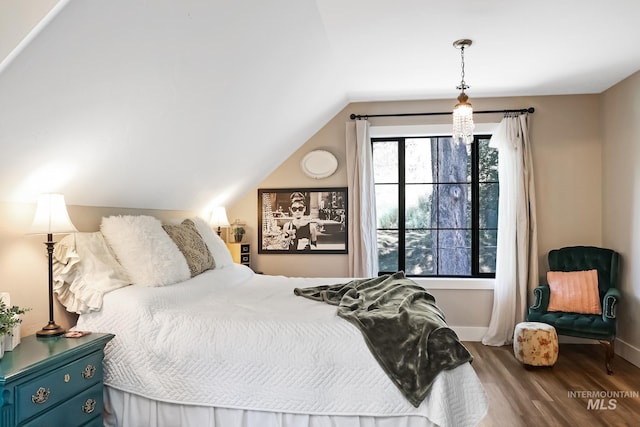 bedroom with wood-type flooring and vaulted ceiling