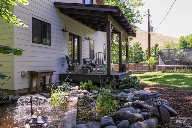 view of yard featuring a wooden deck and a trampoline