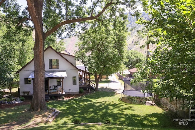 view of yard with a wooden deck and a trampoline