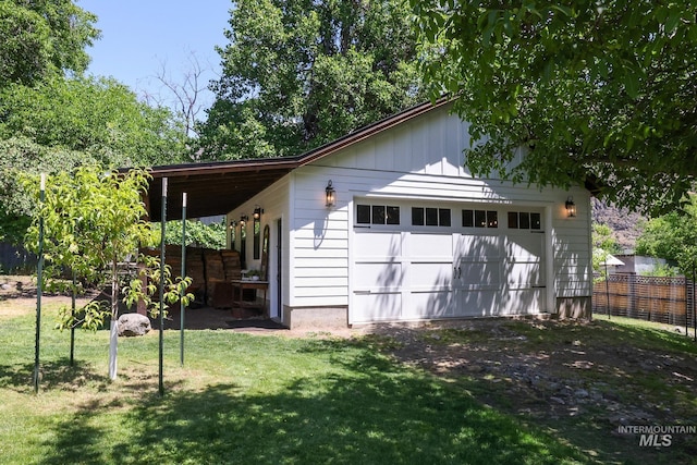 exterior space with a garage, an outdoor structure, and a lawn