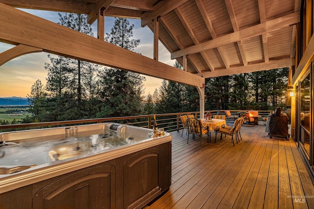 deck at dusk with a hot tub