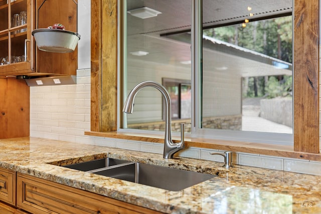 details with light stone counters, sink, and tasteful backsplash