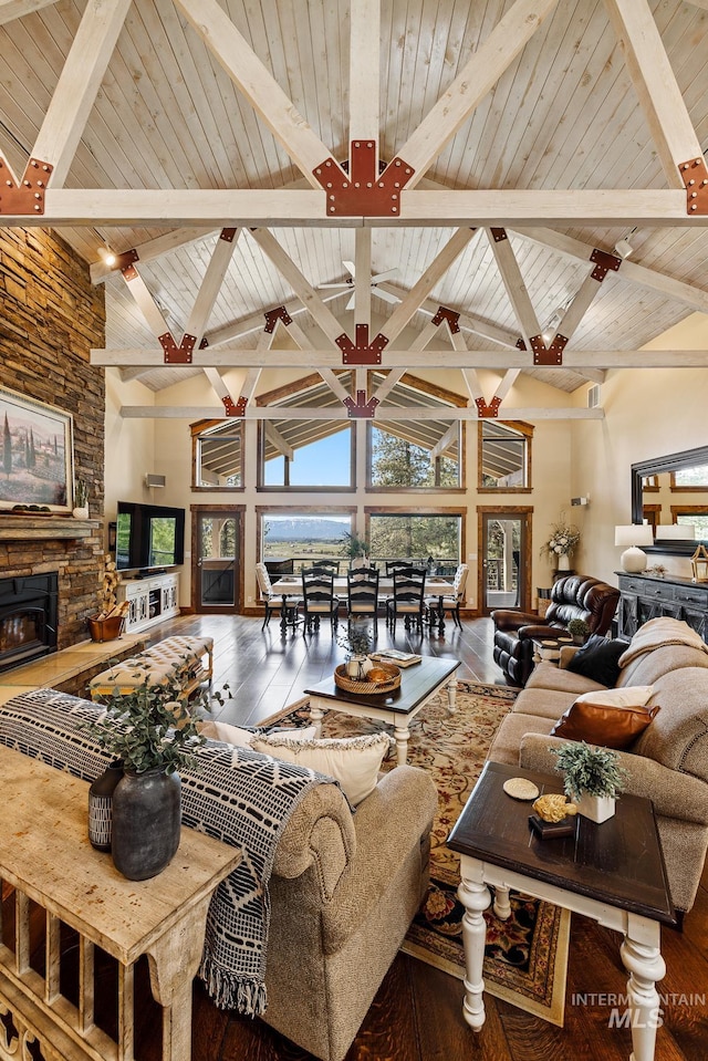 living room with beamed ceiling, high vaulted ceiling, a fireplace, and wood-type flooring