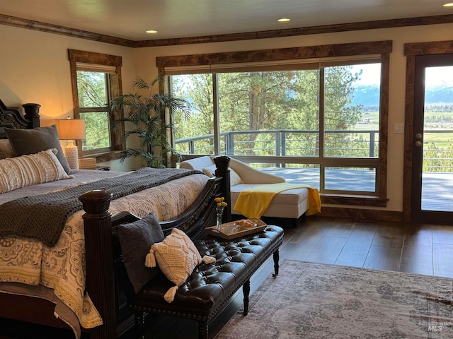 bedroom featuring crown molding, hardwood / wood-style flooring, multiple windows, and access to exterior