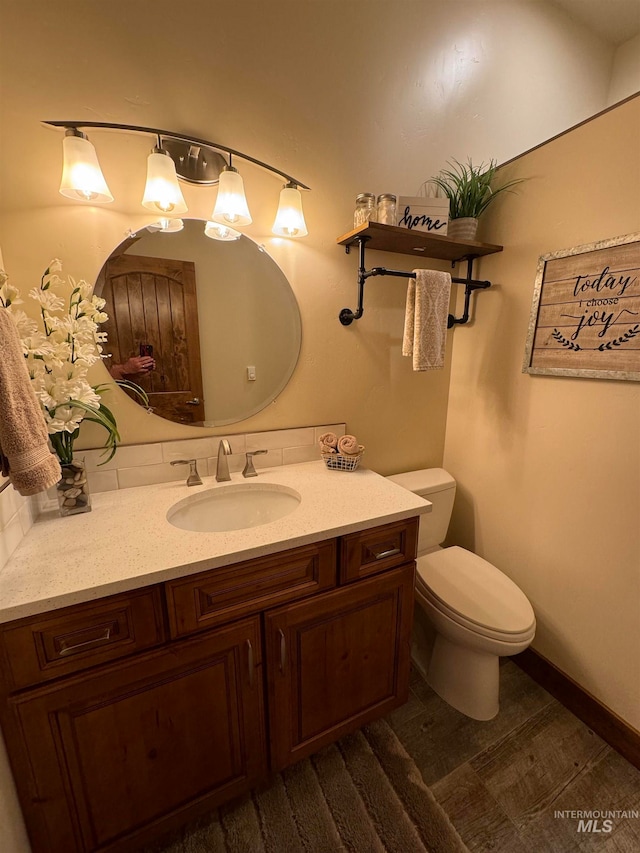 bathroom with hardwood / wood-style floors, vanity, and toilet