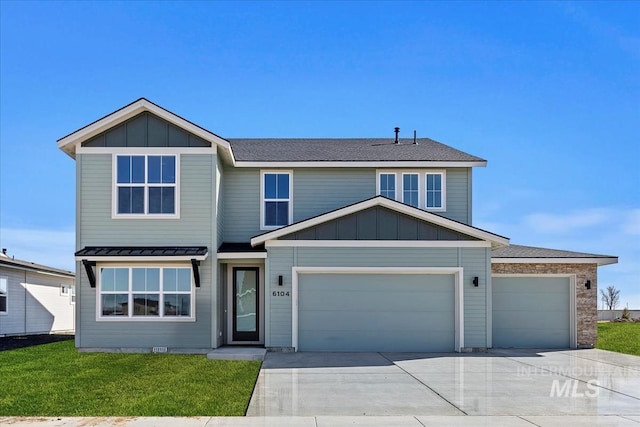 view of front of house with a front yard, concrete driveway, board and batten siding, and an attached garage