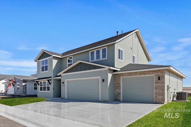 view of front of property featuring central AC unit, concrete driveway, a garage, stone siding, and board and batten siding