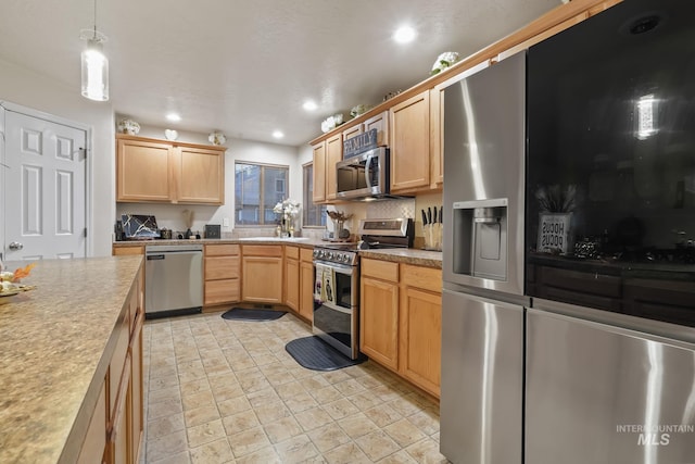 kitchen with light brown cabinets, light countertops, recessed lighting, hanging light fixtures, and stainless steel appliances