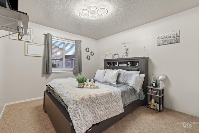 bedroom with carpet flooring, a textured ceiling, and baseboards