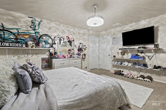 bedroom with baseboards, visible vents, carpet floors, and a textured ceiling