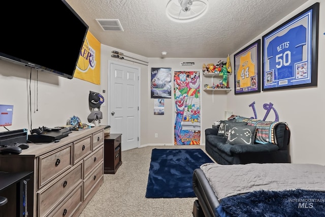 bedroom featuring light carpet, visible vents, and a textured ceiling