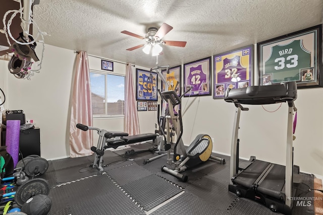 exercise room with baseboards, a textured ceiling, and a ceiling fan