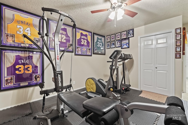 workout area featuring a textured ceiling, baseboards, and a ceiling fan