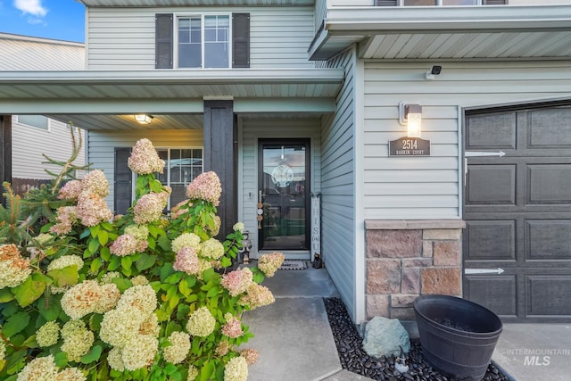 property entrance featuring covered porch and a garage