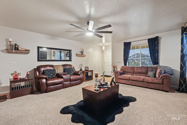 living area featuring carpet, ceiling fan, and a textured ceiling