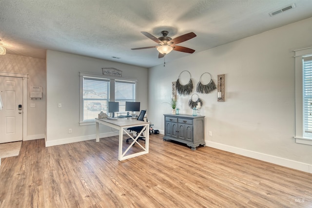 office featuring ceiling fan, light hardwood / wood-style flooring, and a textured ceiling