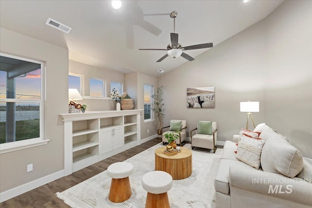 living room with ceiling fan, wood-type flooring, and vaulted ceiling