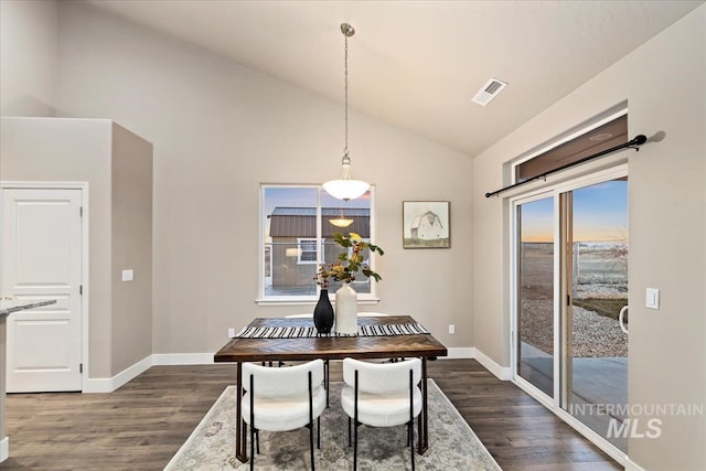 dining area featuring high vaulted ceiling and dark wood-type flooring