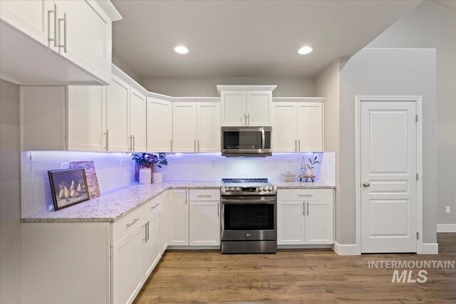 kitchen featuring tasteful backsplash, white cabinets, and stainless steel appliances