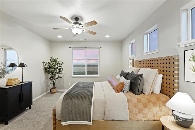 carpeted bedroom featuring ceiling fan and multiple windows