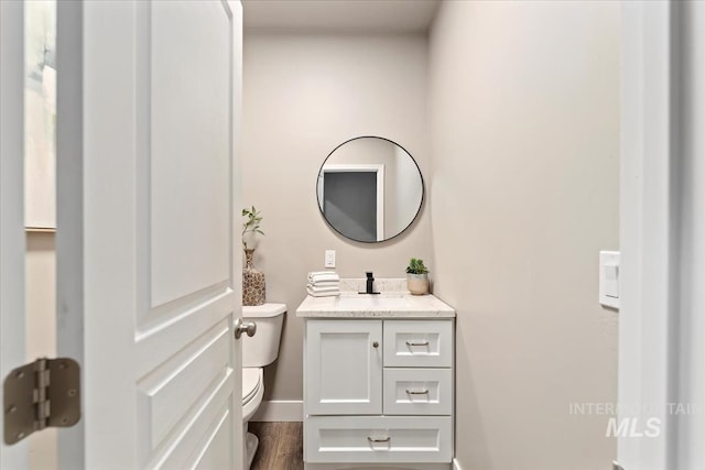 bathroom featuring hardwood / wood-style flooring, vanity, and toilet